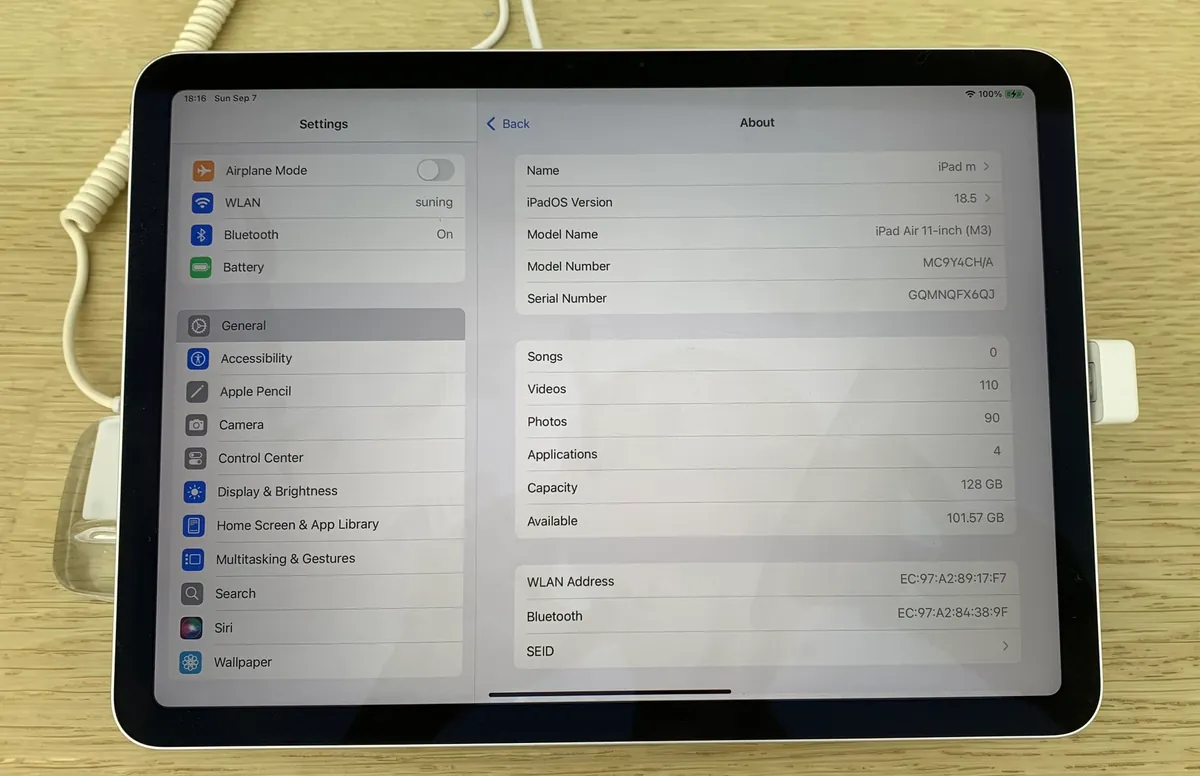 iPad Air 11-inch (M3), front view showing the Settings About screen, on a store display
